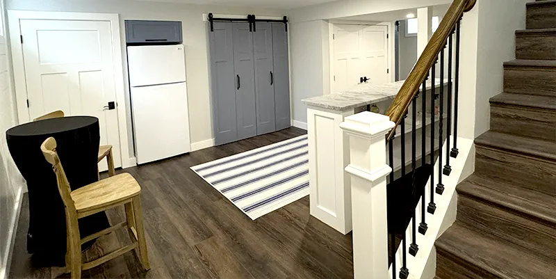 Fully finished luxury basement in Massachusetts featuring modern lighting, custom flooring, and a built-in entertainment center by LK Home Renovations.